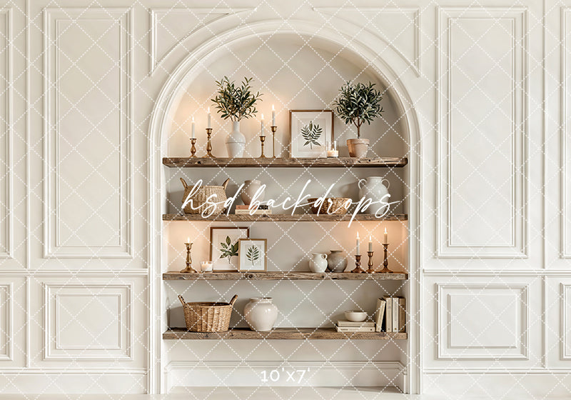 Neutral arched shelf wall photography backdrop with styled wooden shelves, candles, botanical décor, and elegant interior paneling for branding portraits.