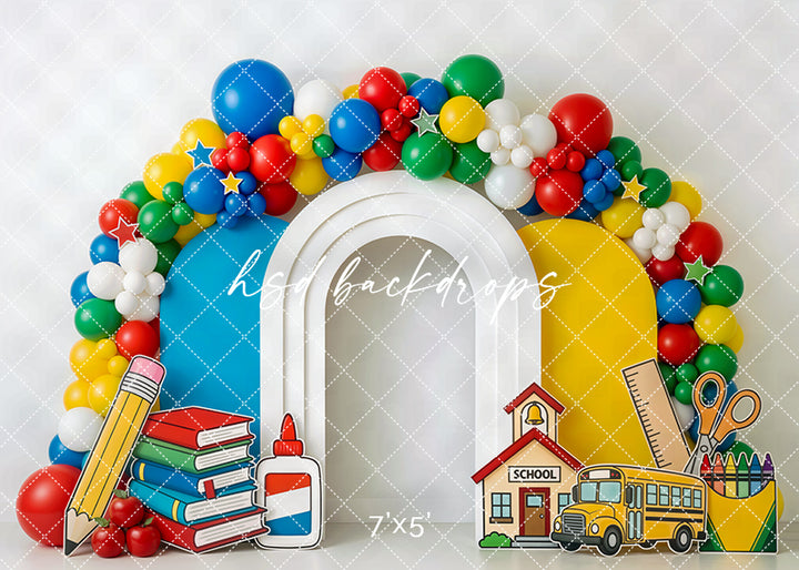 School supplies balloon arch photography backdrop with colorful balloons, books, pencil, glue, ruler, crayons, school bus, and schoolhouse for back-to-school portraits.