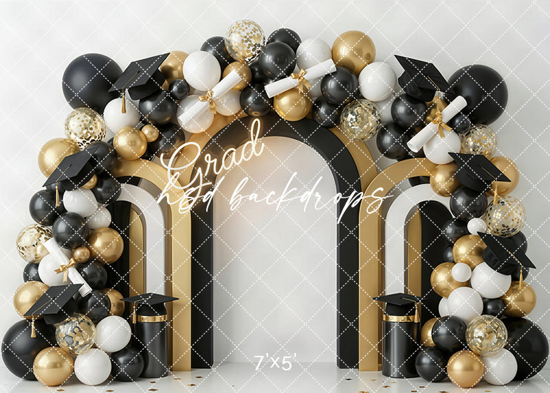 Grad balloon arch photography backdrop with black, white, and gold balloons, graduation caps, diplomas, and a glowing grad sign for graduation portraits.