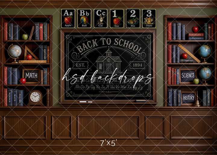 Antique school chalkboard photography backdrop with a vintage classroom chalkboard, wooden bookshelves, books, globes, rulers, apples, and nostalgic schoolroom details for portraits.