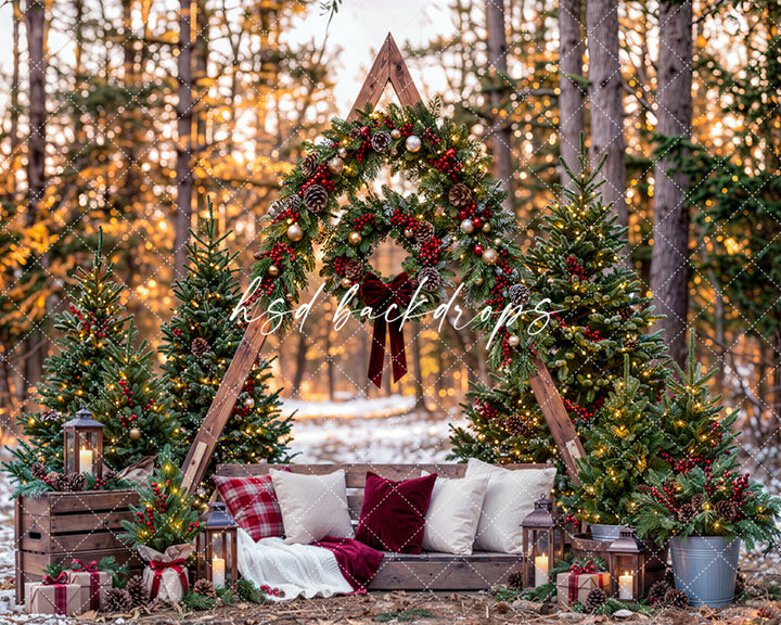 Evergreen Christmas A-frame portrait backdrop with a triangular wooden structure decorated with pine garlands, red berries, metallic ornaments, pinecones, and festive ribbon.