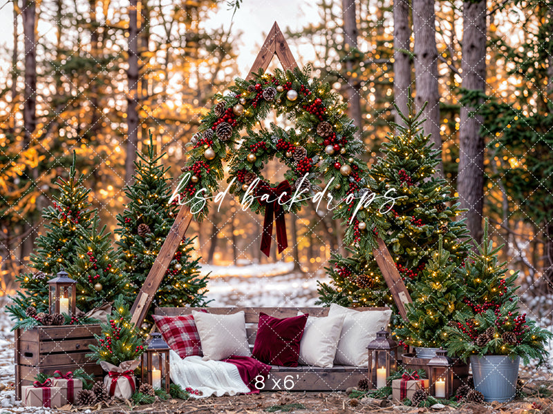 Woodland Christmas A-Frame photography backdrop featuring a rustic wooden arch decorated with evergreen garlands, red berries, pinecones, Christmas trees, lanterns, and a cozy holiday bench.