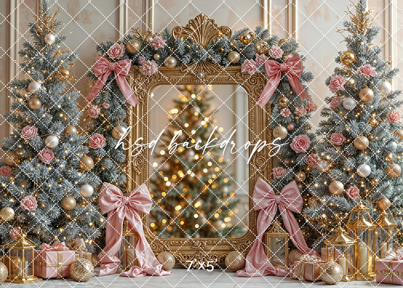 Blush and gold Christmas photo backdrop with frosted trees, bows, roses, and a gilded mirror frame.