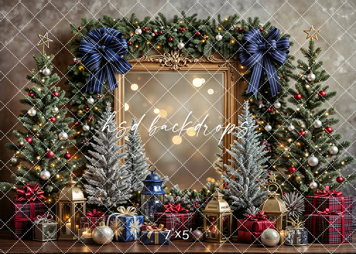 Christmas photo backdrop with navy bows, gold frame, red and blue gifts, trees, and glowing lanterns.
