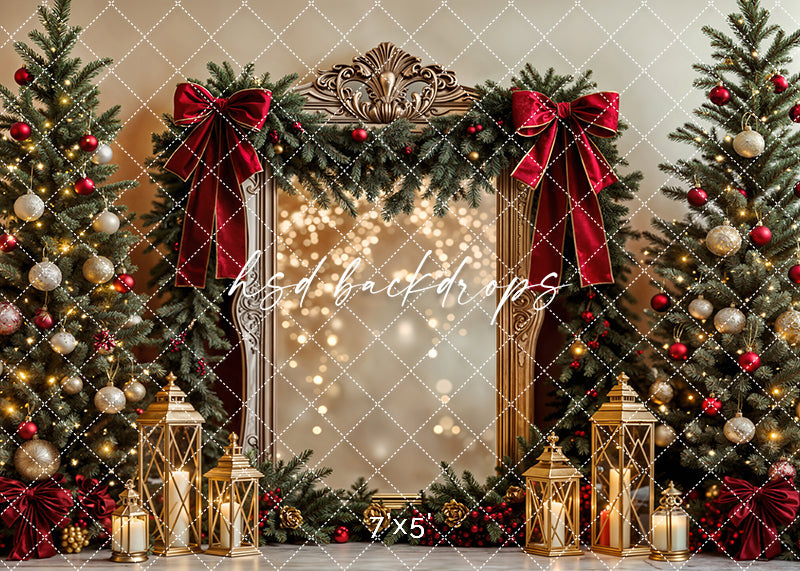 Christmas photo backdrop with velvet red bows, gold frame, lanterns, and decorated trees in a warm holiday setting.