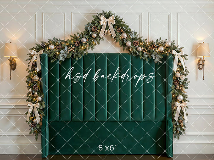 Emerald Holiday Headboard photography backdrop with a green upholstered headboard, festive garland, champagne ornaments, glowing lights, and elegant Christmas bows for portrait photography.