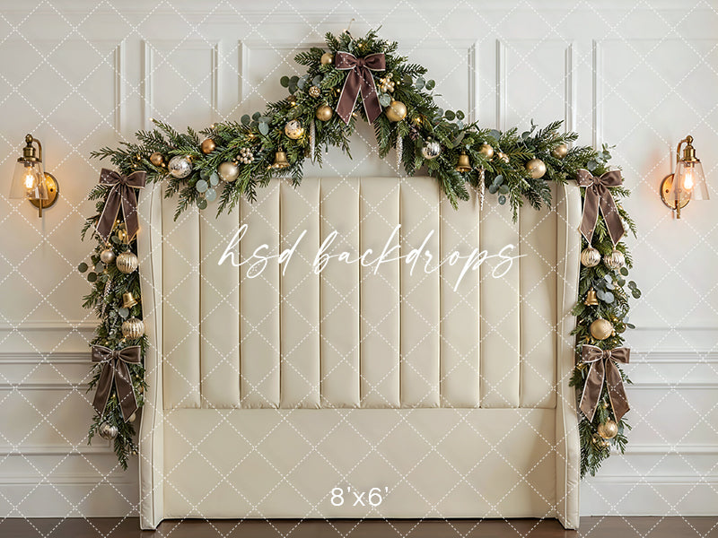 Ivory Garland Headboard photography backdrop with an ivory upholstered headboard, festive garland, champagne ornaments, glowing lights, and classic holiday décor for portrait photography.
