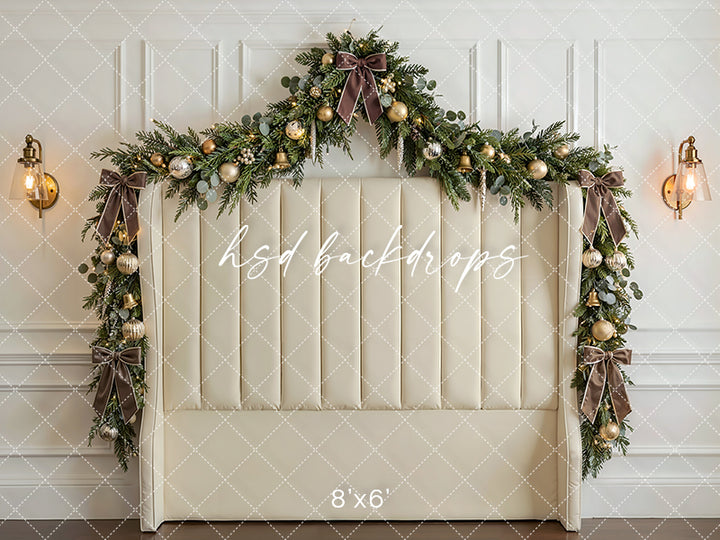 Ivory Garland Headboard photography backdrop with an ivory upholstered headboard, festive garland, champagne ornaments, glowing lights, and classic holiday décor for portrait photography.