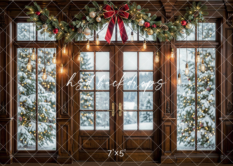 Twinkling Garland Door photography backdrop with wood-framed doors, glowing hanging lights, festive garland, a red bow, and snowy Christmas trees visible through the windows for holiday portrait photography.