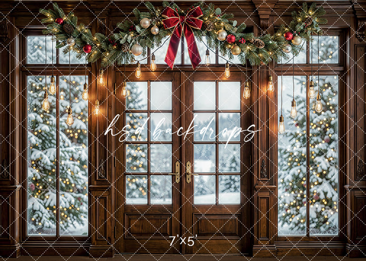 Twinkling Garland Door photography backdrop with wood-framed doors, glowing hanging lights, festive garland, a red bow, and snowy Christmas trees visible through the windows for holiday portrait photography.