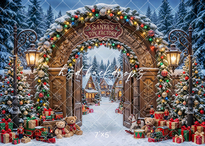 Santa’s Toy Factory Gate photography backdrop with a wooden holiday arch, glowing lanterns, festive garland, toy trains, teddy bears, wrapped gifts, and a snowy Christmas village for portrait photography.