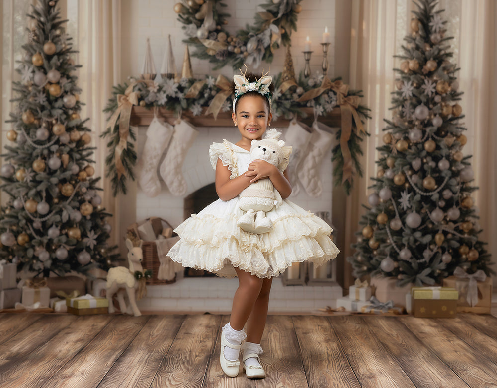 Neutral Christmas fireplace photography backdrop with flocked Christmas trees, ivory mantel, beige stockings, wreath, gold ornaments, wrapped gifts, wood floor, and soft holiday portrait styling.