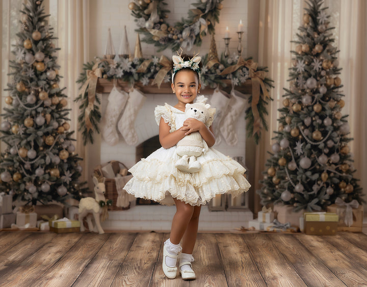Neutral Christmas fireplace photography backdrop with flocked Christmas trees, ivory mantel, beige stockings, wreath, gold ornaments, wrapped gifts, wood floor, and soft holiday portrait styling.