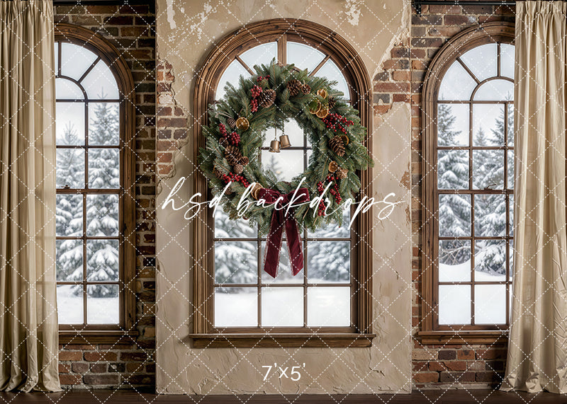Rustic Noel Window photography backdrop with arched brick windows, snowy evergreen views, soft drapery, and a festive wreath with pinecones, bells, and ribbon for holiday portrait photography.