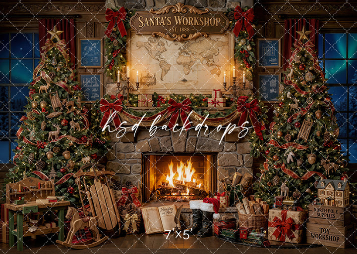 Toymaker Fireplace photography backdrop with a stone fireplace, decorated Christmas trees, red bows, workshop toys, sleds, wrapped gifts, and Santa’s workshop details for holiday portrait photography.