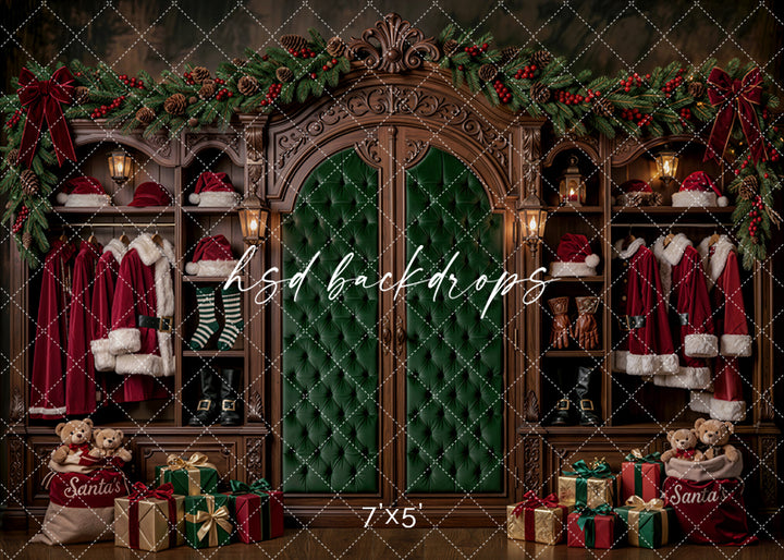 Santa’s Wardrobe Christmas photography backdrop with rich wood cabinets, emerald green tufted doors, Santa suits, boots, stockings, teddy bears, wrapped gifts, garland, red bows, and warm lantern lighting.