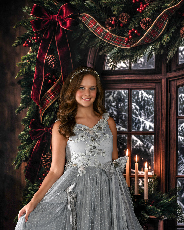 Elegant winter window photography backdrop with arched wooden window, snowy pine trees, lush Christmas garland, deep red bows, wrapped gifts, and cozy holiday portrait details.