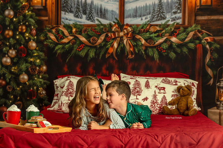 Cozy Cabin Christmas photography backdrop with rustic cabin window, snowy mountain view, burgundy bed, evergreen garland, Christmas tree, warm lanterns, and cozy holiday styling.