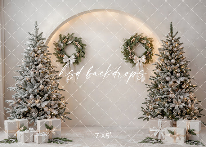 Winter White Christmas Tree photography backdrop with flocked Christmas trees, ivory gift boxes, elegant wreaths, glowing lights, soft neutral walls, and clean winter holiday studio styling.