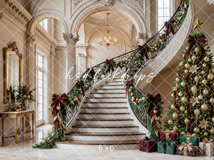 Gilded Christmas Staircase photography backdrop with grand ivory staircase, ornate columns, evergreen garland, burgundy bows, champagne ornaments, decorated Christmas tree, wrapped gifts, and elegant holiday manor styling.