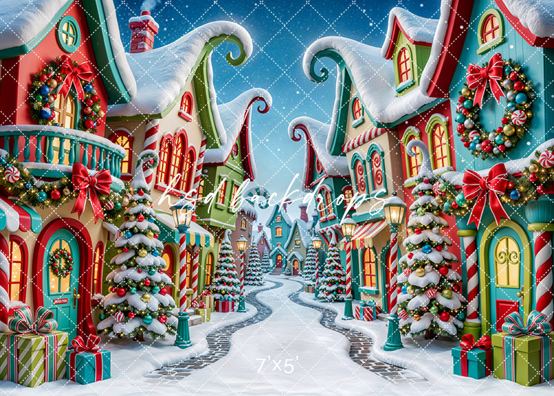 Merryville Christmas Village photography backdrop with colorful snowy buildings, candy-inspired details, decorated Christmas trees, glowing windows, festive wreaths, wrapped gifts, peppermint accents, and whimsical holiday street styling.