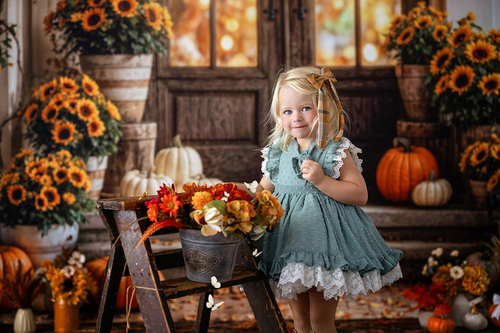 Autumn pumpkin door portrait backdrop with warm rustic entryway, orange sunflowers, stacked pumpkins, fall florals, scattered leaves, and cozy seasonal studio styling.