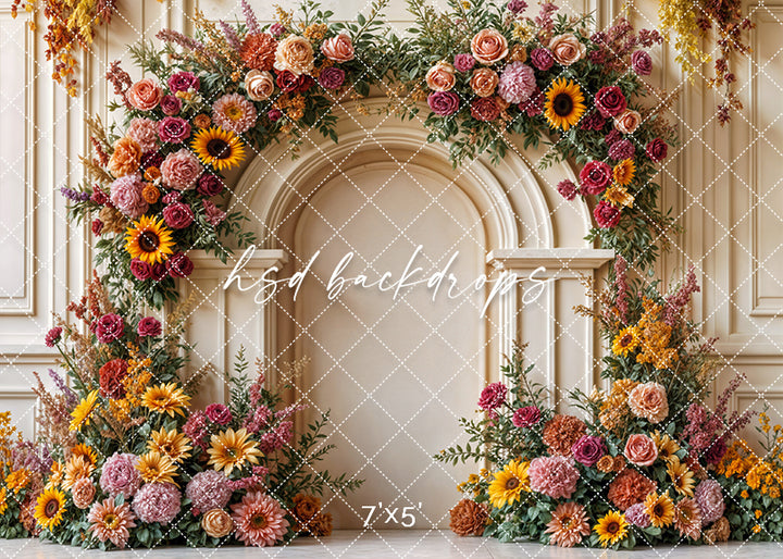 Golden harvest floral arch backdrop with sunflowers, roses, and autumn blooms