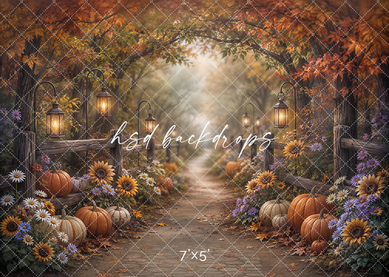 Autumn Pumpkin Path photography backdrop with a rustic woodland trail, pumpkins, sunflowers, daisies, purple wildflowers, wooden fencing, lanterns, and colorful fall foliage.
