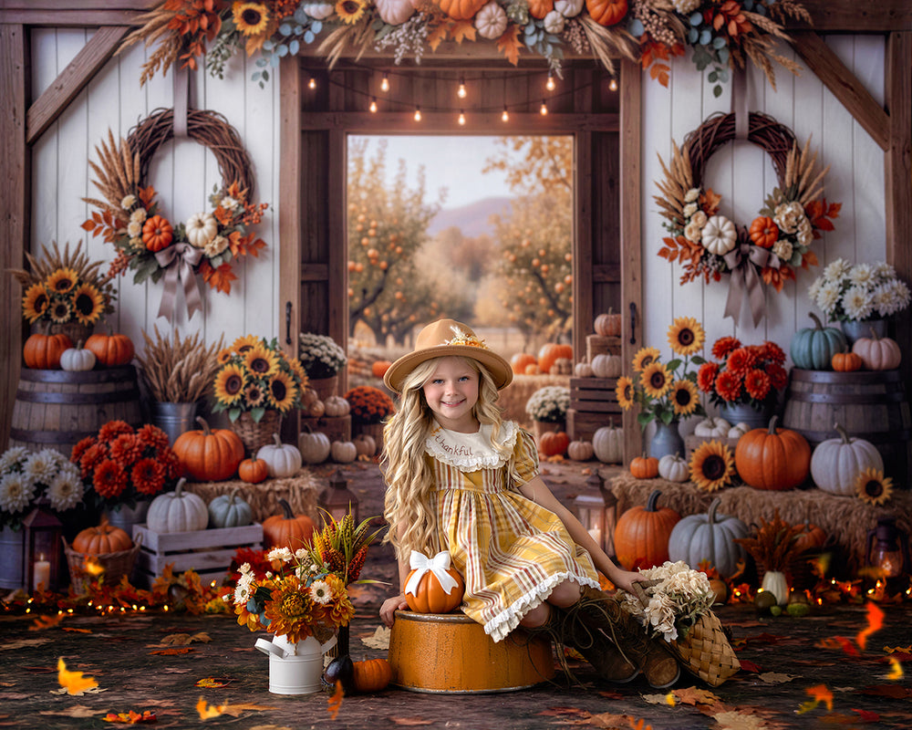 Rustic fall pumpkin barn photography backdrop featuring autumn wreaths, orange and white pumpkins, sunflowers, hay bales, and a charming harvest scene with a young girl.
