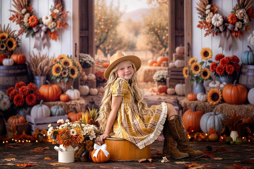 Autumn harvest barn photography backdrop with a young girl in a yellow plaid dress surrounded by pumpkins, sunflowers, fall flowers, rustic barrels, and warm string lights.