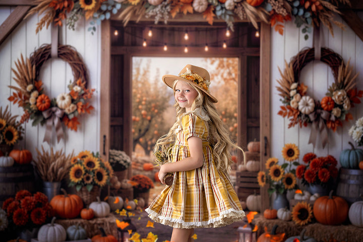 Fall pumpkin patch photography backdrop featuring a rustic barn entrance, colorful pumpkins, sunflower arrangements, autumn wreaths, and a beautiful orchard view.