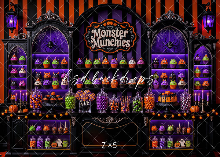 Monster Munchies Halloween photography backdrop with colorful monster treats, candy jars, lollipops, purple display shelves, black and orange striped wall, glowing lanterns, pumpkins, spider details, and spooky sweet shop styling.