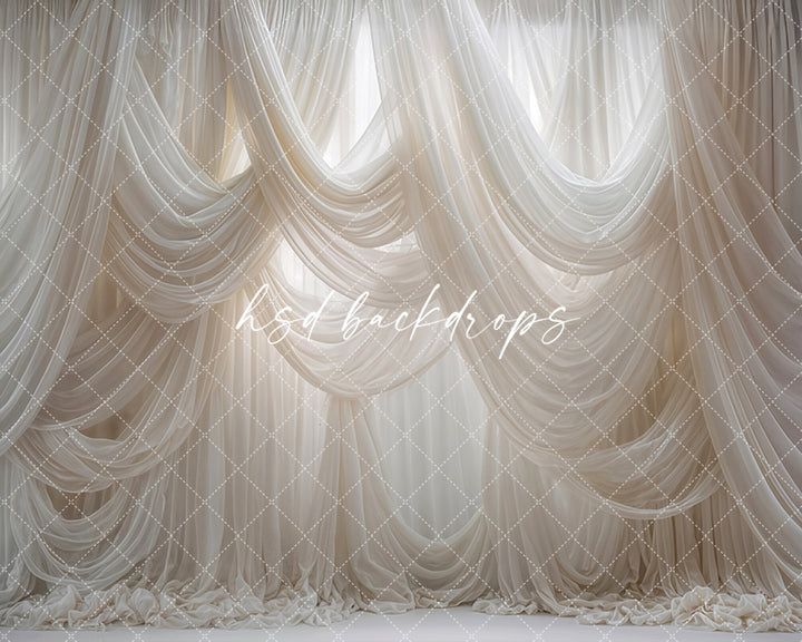 White draped fabric photography backdrop with soft layered curtains.