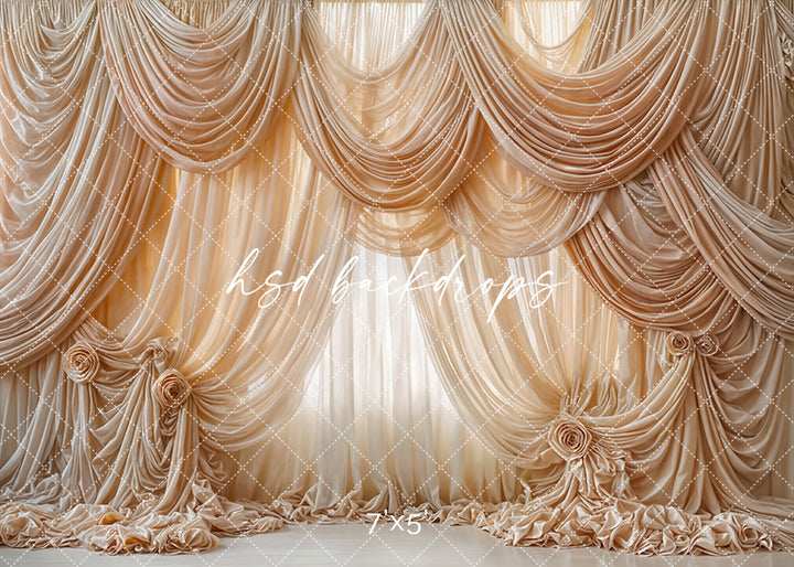 Champagne draped photography backdrop with layered silk folds, large fabric rosettes, and luxurious couture-inspired detailing for elegant portrait sessions.