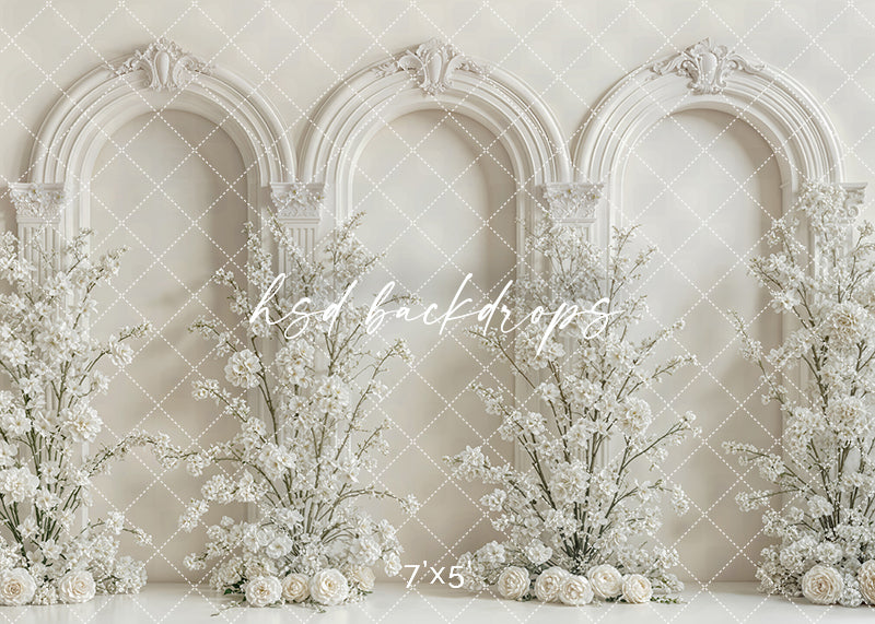 Elegant ivory arch floral backdrop with ornate archways and white blossoms for photography sessions.