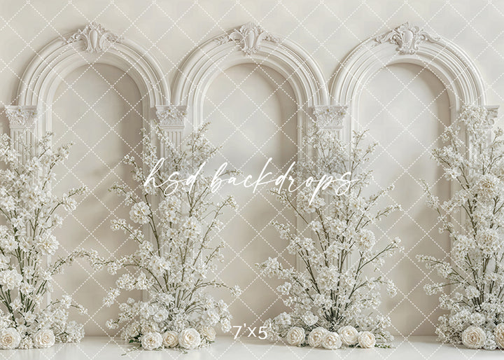 Elegant ivory arch floral backdrop with ornate archways and white blossoms for photography sessions.