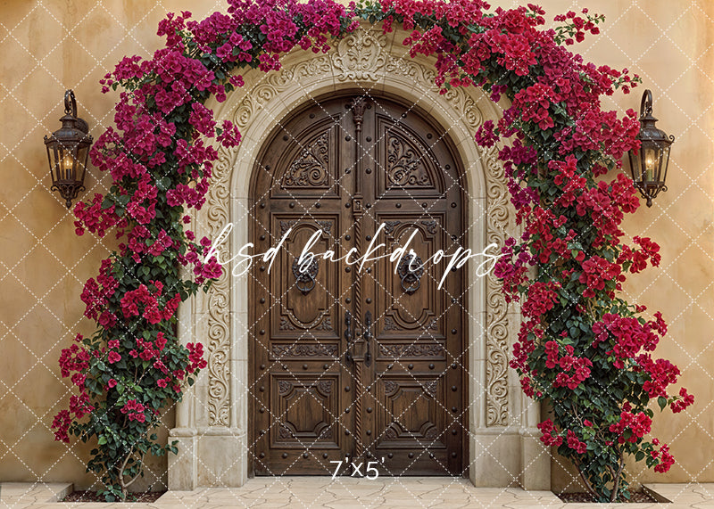 Spanish hacienda photography backdrop with carved stone arch, wooden double doors, and cascading crimson bougainvillea flowers