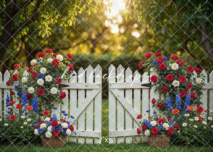 Fourth of July garden gate photography backdrop with white picket gate, red white and blue flowers, and rustic outdoor setting for patriotic portraits.