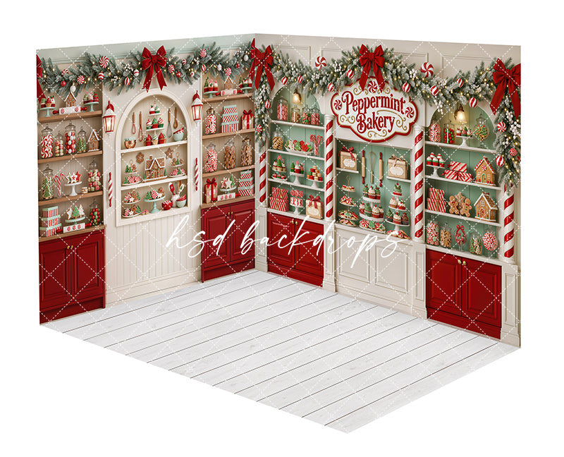 Whimsical Peppermint Bakery room photography backdrop with red and white cabinetry, candy cane columns, peppermint accents, festive garland, holiday treats, wrapped gifts, and bright white floor.
