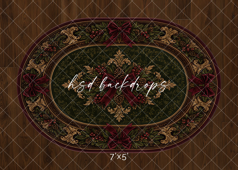 Heirloom Christmas rug photography backdrop with deep green oval rug design, burgundy ribbon accents, ornate gold details, pine greenery, berries, and warm wood floor styling for holiday portraits.