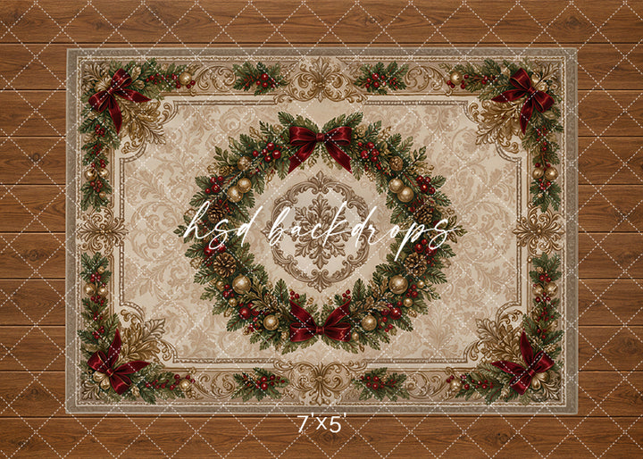 Vintage Christmas wreath rug photography backdrop with ivory rug design, ornate gold details, evergreen wreath centerpiece, burgundy bows, red berries, pine greenery, and warm wood floor styling for holiday portraits.
