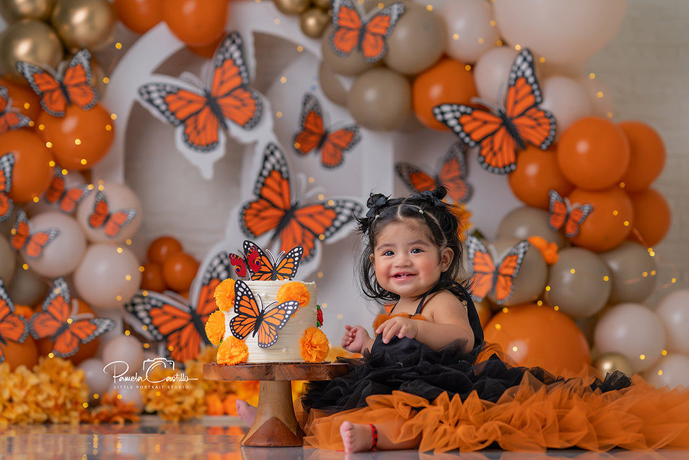 Monarch Butterfly birthday photography backdrop with orange and neutral balloon clusters, oversized monarch butterflies, and warm floral accents for girls birthday portraits.