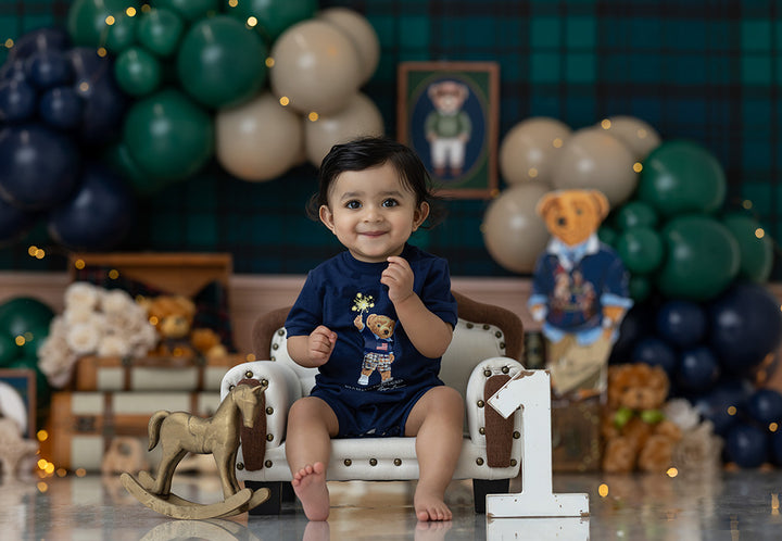 Classy Boy birthday photography backdrop with navy, green, and cream balloons, plaid background, vintage suitcases, books, teddy bears, and elegant birthday styling for boys portraits.
