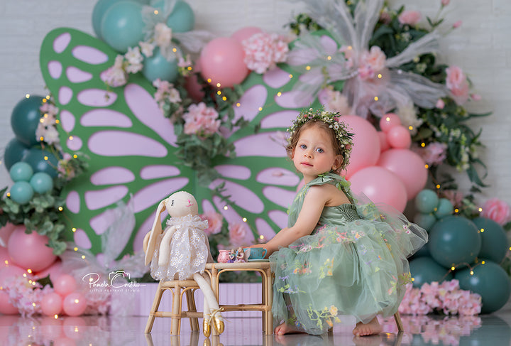 Mint Butterfly Birthday photography backdrop with oversized mint butterfly wings, blush pink balloons, florals, greenery, and whimsical butterfly accents for girls portrait photography.