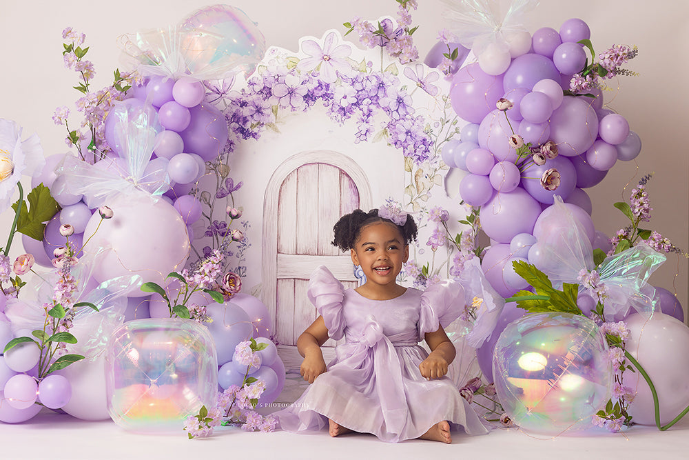 Lavender Fairy Door photography backdrop with a pastel fairy door, lavender balloons, floral accents, iridescent butterflies, and whimsical garden styling for portrait photography.
