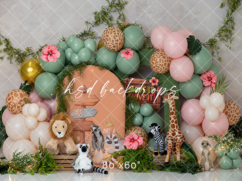 Move It! Move It! Jungle Animals photography backdrop featuring pastel safari balloons, adorable jungle animals, tropical greenery, pink hibiscus flowers, and a peach safari hut.