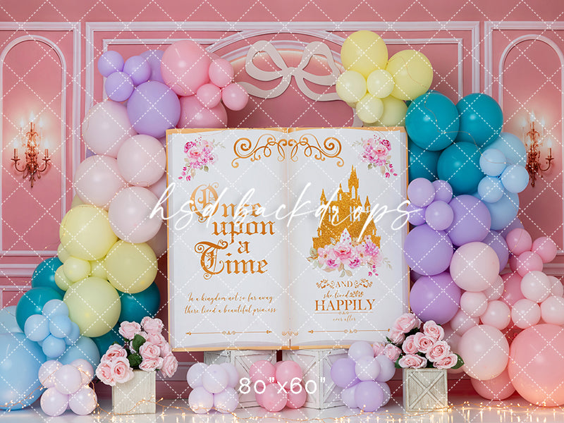 Once Upon a Birthday photography backdrop featuring an oversized fairytale storybook with golden princess castle, pastel pink, lavender, yellow, turquoise, and blue balloon garlands, delicate pink roses, elegant pink palace walls, and whimsical princess birthday decorations for first birthday and cake smash portraits.