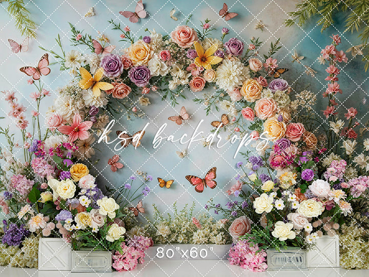 Photography backdrop with pastel flower arch and butterflies – Butterfly Blooms Garden Arch by HSD Backdrops.