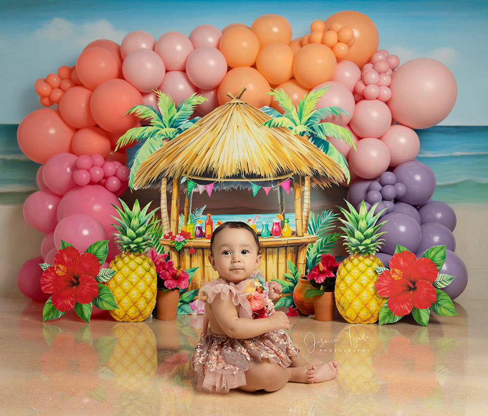 Tiki Tropic Sunset Stand photo backdrop with beach view, balloon arch, tiki hut, pineapples, and hibiscus 