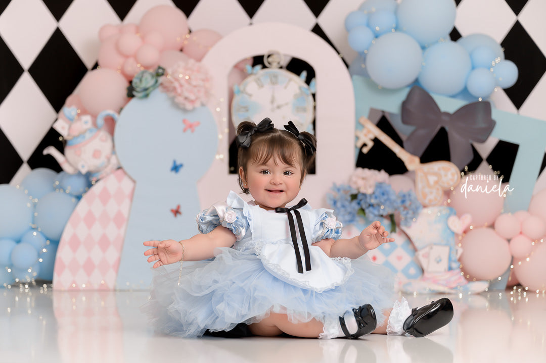 Whimsical Wonderland Tea Party backdrop with pastel balloons, tea props, and keyhole design.
